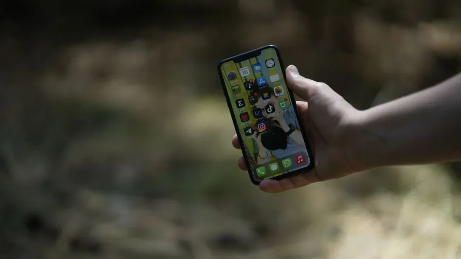 Hand som håller en smartphone utomhus - prisjämförelse av mobilabonnemang i Sverige 2026