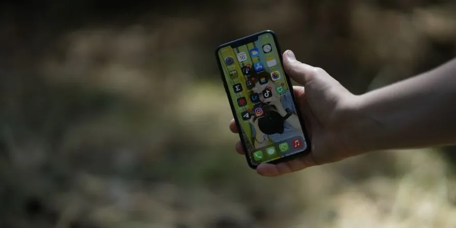 Hand som håller en smartphone utomhus - prisjämförelse av mobilabonnemang i Sverige 2026